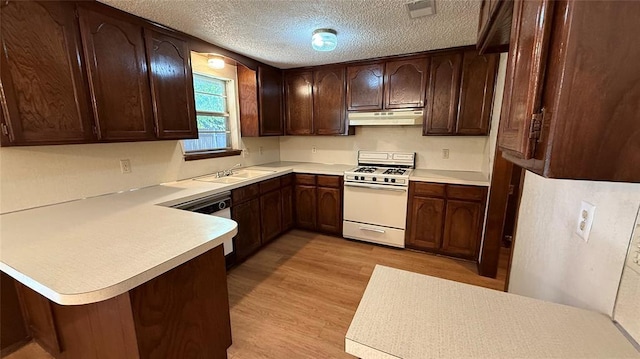 3308 Resh Ct, Norman, OK 73072 - kitchen featuring gas range gas stove, under cabinet range hood, light countertops, a peninsula, and a textured ceiling