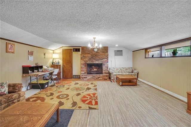 207 E Pine Ave, Sayre, OK 73662 - living room featuring wood finished floors, a wall mounted AC, a chandelier, a textured ceiling, and a brick fireplace