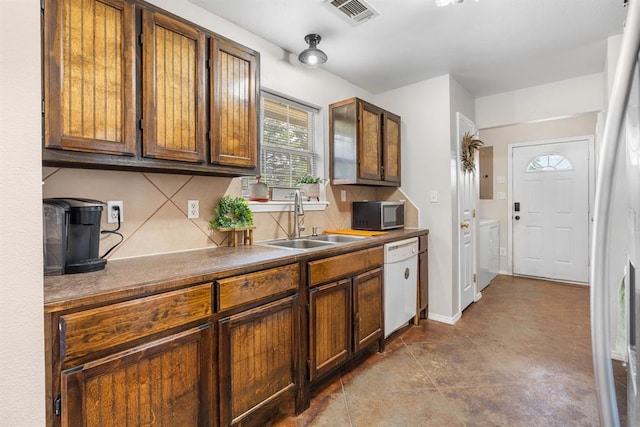 275 S Ranchette Rd, Mead, OK 73449 - kitchen with dishwasher, washing machine and clothes dryer, decorative backsplash, and brown cabinetry