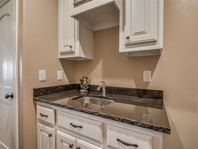 19855 Walker Rd, Mcloud, OK 74851 - kitchen with white cabinets, a textured wall, and dark stone countertops