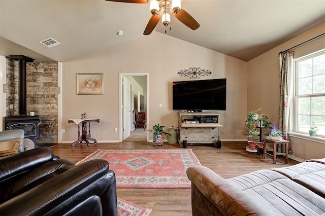 19100 SE 134th St, Mcloud, OK 74851 - living area featuring vaulted ceiling, ceiling fan, wood finished floors, and a wood stove