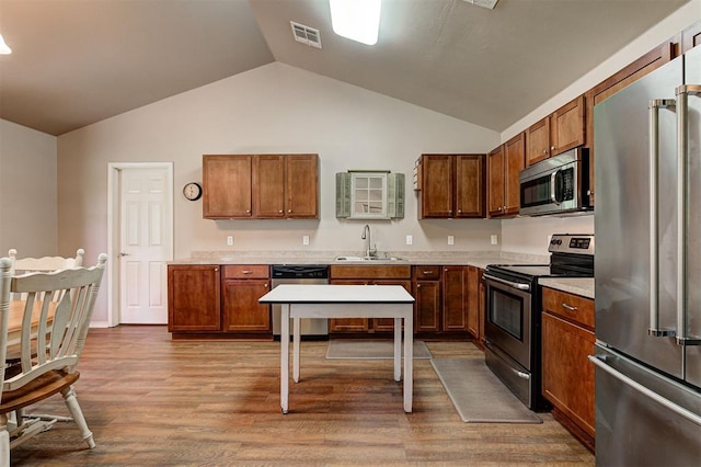 19100 SE 134th St, Mcloud, OK 74851 - kitchen with appliances with stainless steel finishes, lofted ceiling, light countertops, wood finished floors, and brown cabinets