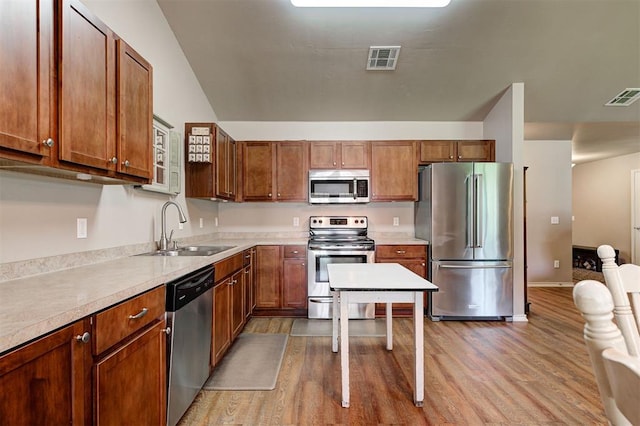 19100 SE 134th St, Mcloud, OK 74851 - kitchen featuring appliances with stainless steel finishes, light wood-style flooring, and brown cabinetry
