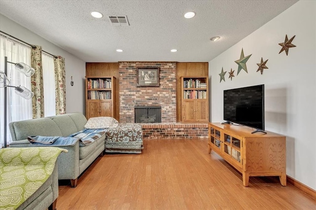 331249 E 1020th Rd, Harrah, OK 73045 - living area with a textured ceiling, light wood-style floors, a fireplace, and recessed lighting