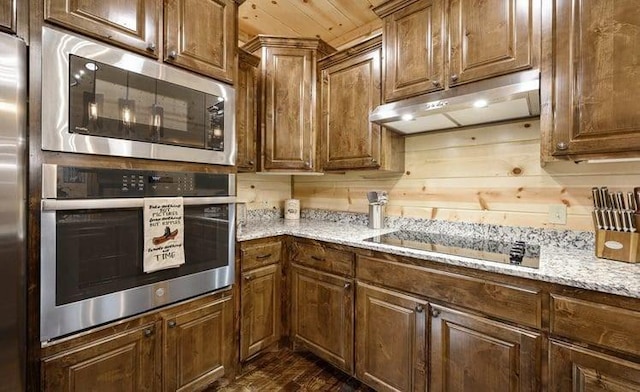 1723 Pine Hills Rd, Broken Bow, OK 74728 - kitchen with appliances with stainless steel finishes, under cabinet range hood, light stone counters, and brown cabinets