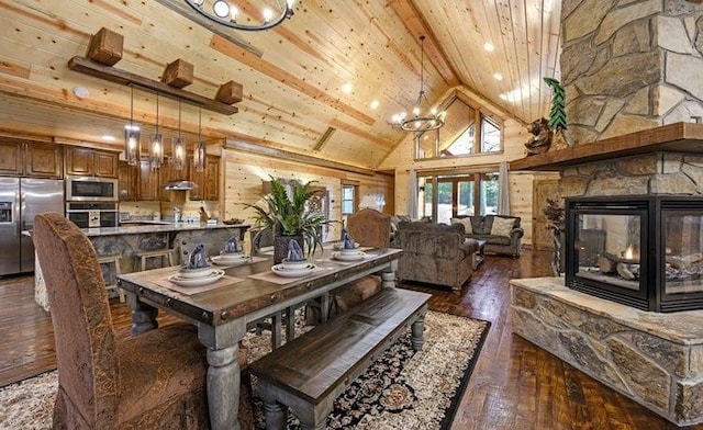 1723 Pine Hills Rd, Broken Bow, OK 74728 - dining room with a wood ceiling with exposed beams, dark wood-style floors, high vaulted ceiling, a fireplace, and a chandelier