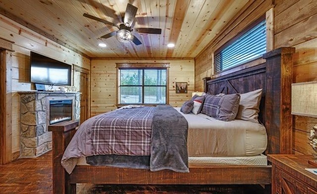 1723 Pine Hills Rd, Broken Bow, OK 74728 - bedroom with a glass covered fireplace, wood walls, wooden ceiling, wood-type flooring, and recessed lighting