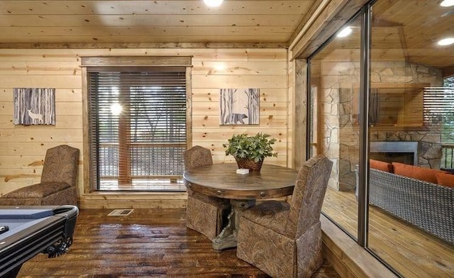 1723 Pine Hills Rd, Broken Bow, OK 74728 - dining area featuring wooden ceiling, wooden walls, wood-type flooring, and a stone fireplace