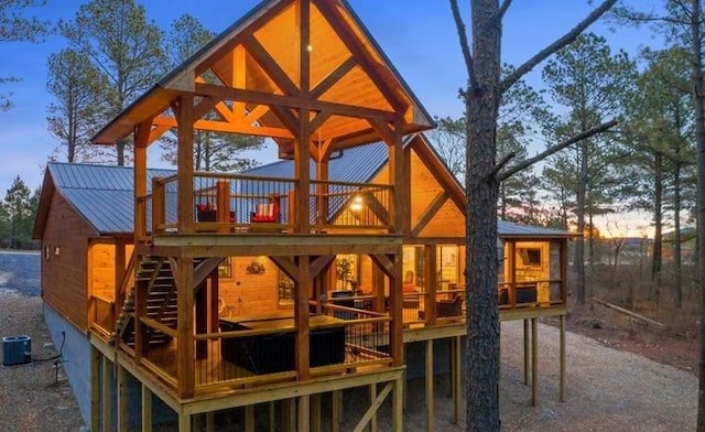 1723 Pine Hills Rd, Broken Bow, OK 74728 - back of property at dusk featuring a wooden deck and a metal roof