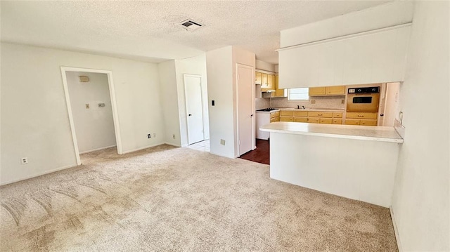 2719 Osage Way, Norman, OK 73071 - kitchen with white oven, carpet, light countertops, gas stovetop, and a textured ceiling