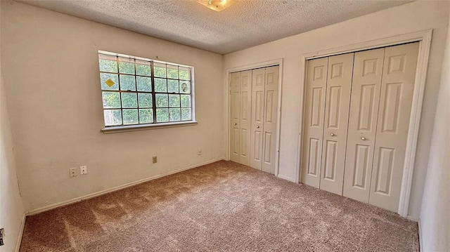 2719 Osage Way, Norman, OK 73071 - unfurnished bedroom with two closets, carpet flooring, and a textured ceiling
