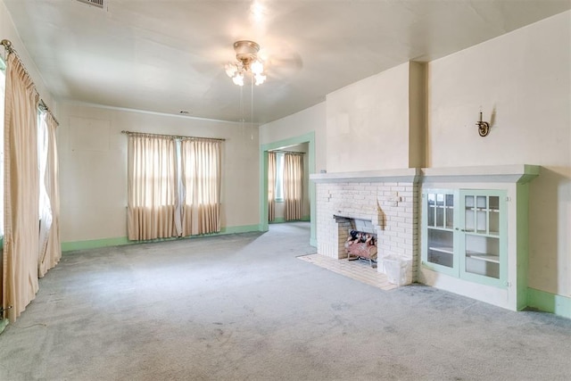 121 NW 26th St, Oklahoma City, OK 73103 - unfurnished living room featuring carpet floors, a ceiling fan, and a fireplace