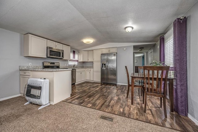 6550 N Indian Meridian Rd, Coyle, OK 73027 - kitchen with appliances with stainless steel finishes, heating unit, lofted ceiling, a textured ceiling, and a peninsula