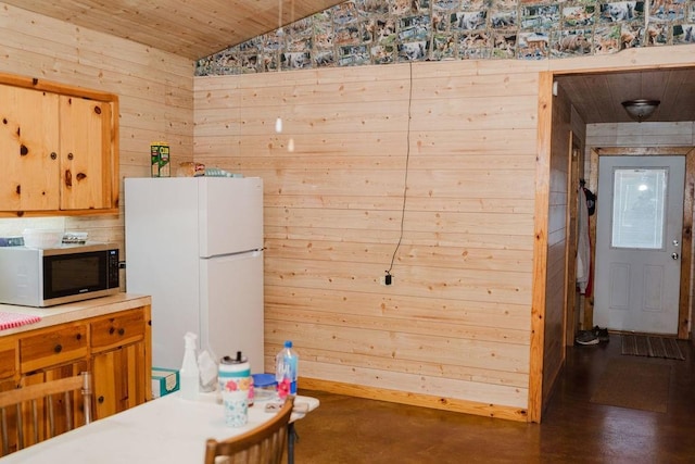 12223 N 2040th Rd, Sentinel, OK 73664 - kitchen featuring stainless steel microwave, freestanding refrigerator, wood walls, lofted ceiling, and wood ceiling