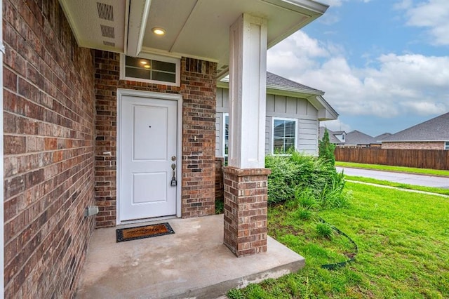 4217 NW 151st St, Edmond, OK 73013 - view of exterior entry featuring brick siding, a lawn, and board and batten siding