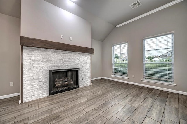 4217 NW 151st St, Edmond, OK 73013 - unfurnished living room featuring vaulted ceiling, wood finished floors, a fireplace, and crown molding
