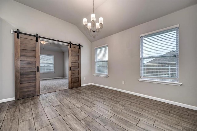 4217 NW 151st St, Edmond, OK 73013 - empty room featuring a barn door, wood tiled floors, lofted ceiling, and a chandelier