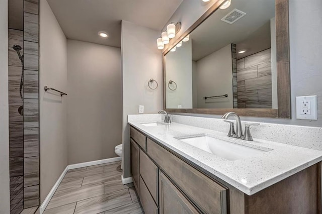 4217 NW 151st St, Edmond, OK 73013 - bathroom featuring double vanity, tiled shower, and recessed lighting