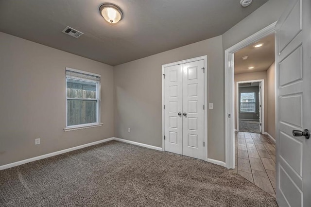 4217 NW 151st St, Edmond, OK 73013 - unfurnished bedroom featuring multiple windows, light carpet, and a closet