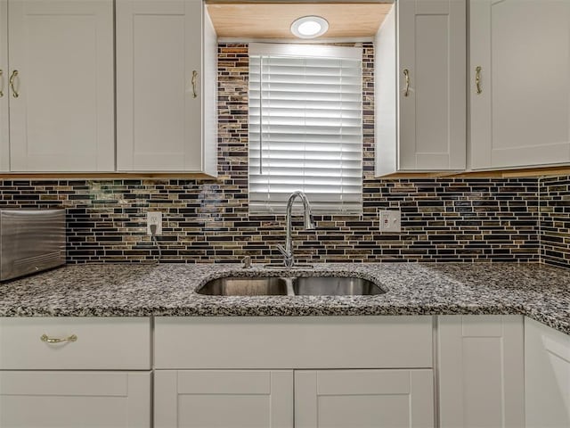 2837 SW 63rd St, Oklahoma City, OK 73159 - kitchen with white cabinets, decorative backsplash, and dark stone counters