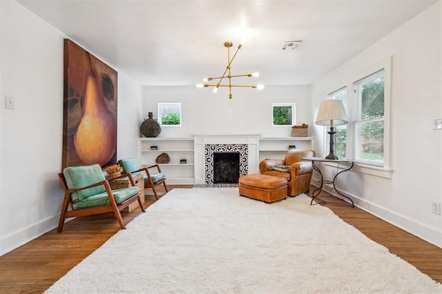 1828 NW 40th St, Oklahoma City, OK 73118 - sitting room featuring a chandelier, healthy amount of natural light, wood finished floors, and a fireplace with flush hearth