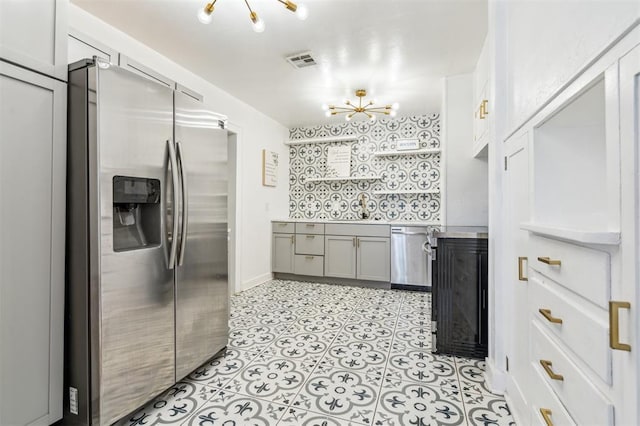 1828 NW 40th St, Oklahoma City, OK 73118 - kitchen with appliances with stainless steel finishes, a chandelier, light countertops, and gray cabinetry