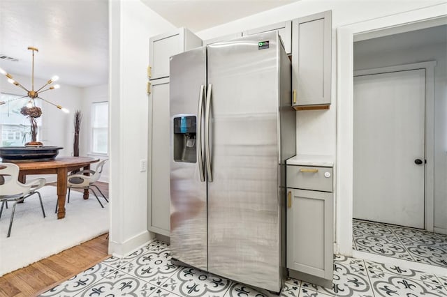 1828 NW 40th St, Oklahoma City, OK 73118 - kitchen with stainless steel fridge, gray cabinets, a chandelier, and light countertops