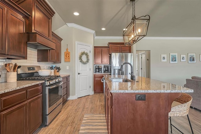 1101 Northridge Blvd, Altus, OK 73521 - kitchen with stainless steel appliances, crown molding, a center island with sink, light wood-style flooring, and tasteful backsplash