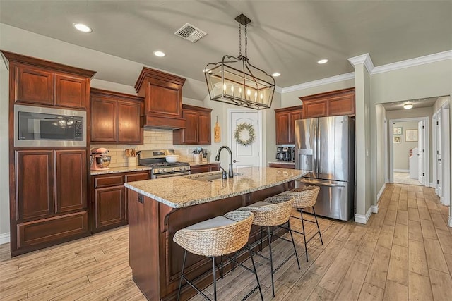 1101 Northridge Blvd, Altus, OK 73521 - kitchen featuring stainless steel appliances, crown molding, a breakfast bar, backsplash, and a center island with sink