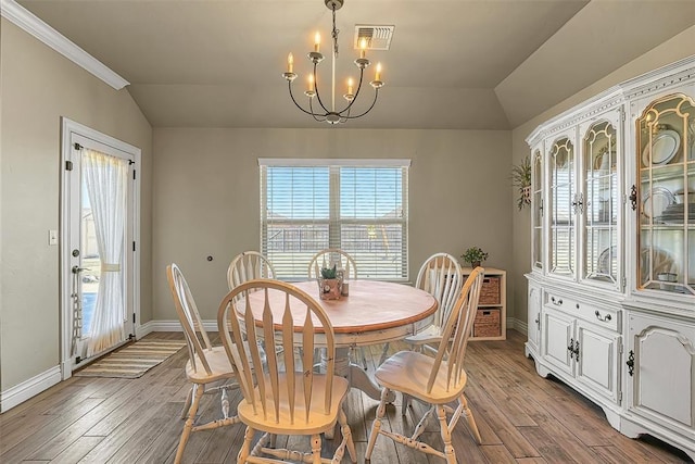 1101 Northridge Blvd, Altus, OK 73521 - dining area with lofted ceiling, plenty of natural light, a chandelier, light wood-style floors, and crown molding