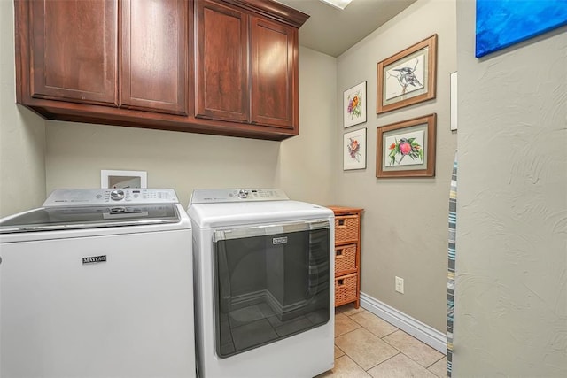 1101 Northridge Blvd, Altus, OK 73521 - laundry area featuring cabinet space, washing machine and clothes dryer, and light tile patterned floors