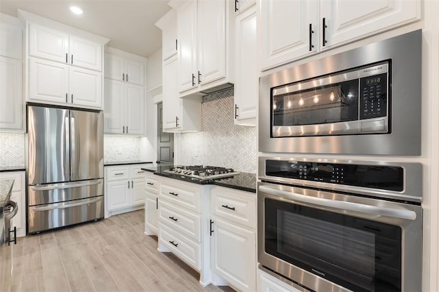 16101 Villa Valeria Way, Edmond, OK 73013 - kitchen with appliances with stainless steel finishes, white cabinets, light wood-style flooring, backsplash, and recessed lighting