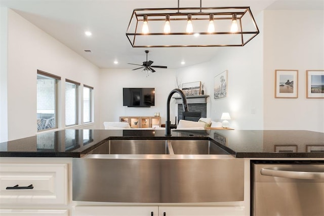 16101 Villa Valeria Way, Edmond, OK 73013 - kitchen featuring stainless steel dishwasher, open floor plan, a fireplace, dark stone countertops, and recessed lighting