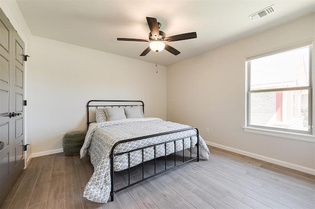 16101 Villa Valeria Way, Edmond, OK 73013 - bedroom featuring wood finished floors, multiple windows, and ceiling fan