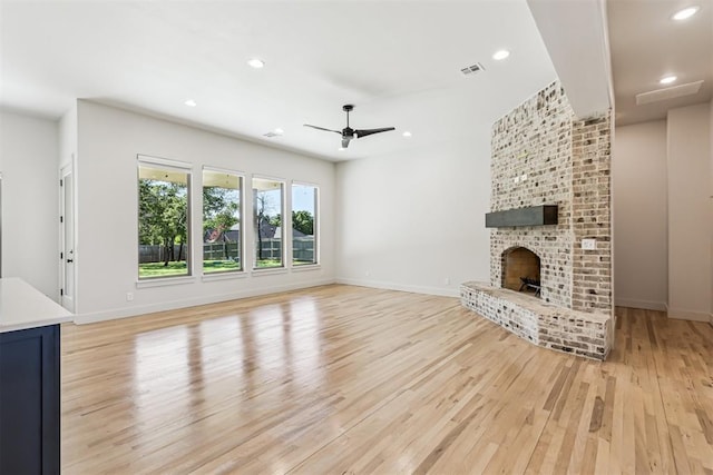 1690 Shaylee Ln, Choctaw, OK 73020 - unfurnished living room featuring light wood finished floors, a ceiling fan, recessed lighting, and a brick fireplace