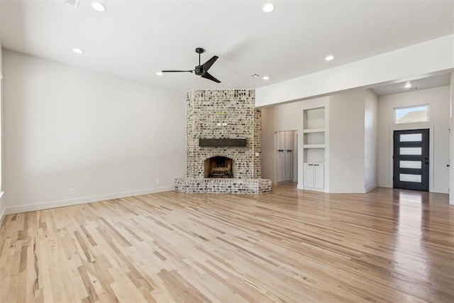 1690 Shaylee Ln, Choctaw, OK 73020 - unfurnished living room featuring ceiling fan, a brick fireplace, recessed lighting, light wood finished floors, and built in shelves
