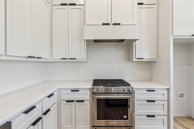 1690 Shaylee Ln, Choctaw, OK 73020 - kitchen featuring stainless steel range with gas stovetop, decorative backsplash, white cabinets, light stone countertops, and custom range hood