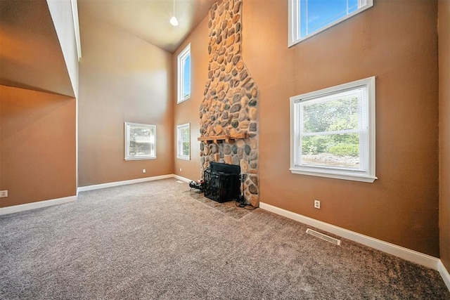 14500 Billy Dr, Edmond, OK 73034 - carpeted living room featuring a high ceiling, healthy amount of natural light, and a wood stove