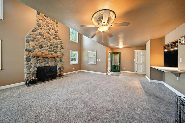14500 Billy Dr, Edmond, OK 73034 - unfurnished living room featuring ceiling fan, carpet floors, a wood stove, a textured ceiling, and a towering ceiling