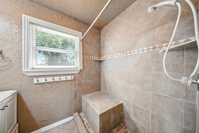14500 Billy Dr, Edmond, OK 73034 - bathroom with tiled shower, vanity, and a textured wall