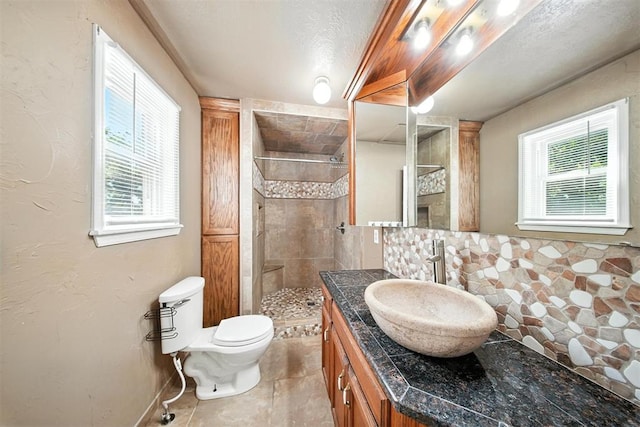 14500 Billy Dr, Edmond, OK 73034 - full bath featuring vanity, a tile shower, decorative backsplash, tile patterned flooring, and a textured ceiling