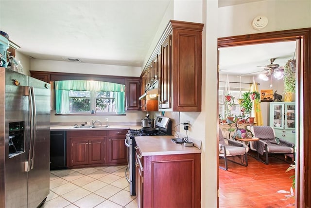 213 Country Club Ter, Oklahoma City, OK 73110 - kitchen with stainless steel appliances, light countertops, under cabinet range hood, a ceiling fan, and light tile patterned flooring
