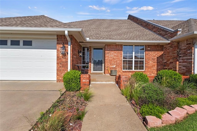 901 Gartrell Pl, Weatherford, OK 73096 - property entrance featuring a shingled roof, brick siding, concrete driveway, and an attached garage