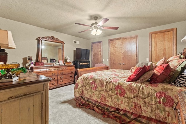 901 Gartrell Pl, Weatherford, OK 73096 - bedroom featuring light carpet, a textured ceiling, a ceiling fan, and multiple closets