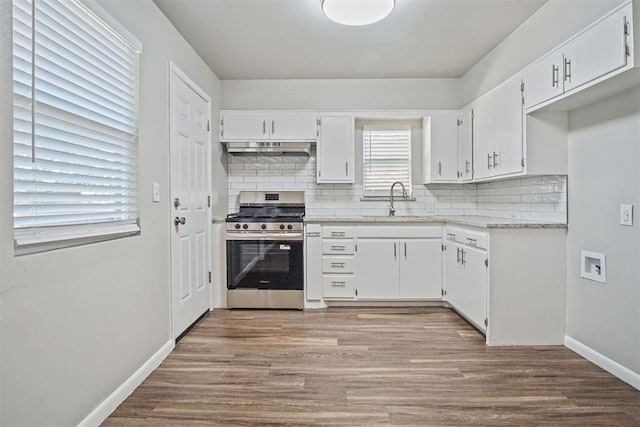 909 Buck Dr, Shawnee, OK 74801 - kitchen with stainless steel gas range, backsplash, white cabinets, and wood finished floors