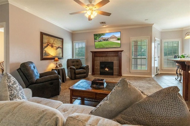 1106 Prairie Dunes Ct, Norman, OK 73072 - living area featuring ceiling fan, a tiled fireplace, ornamental molding, and tile patterned flooring
