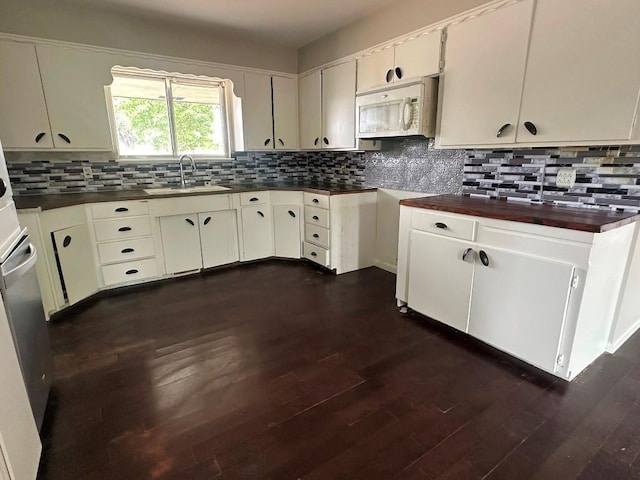 115 S Main St, Sharon, OK 73857 - kitchen with white microwave, tasteful backsplash, and dark wood-type flooring