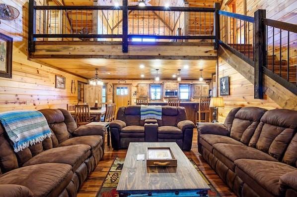 708 Split Creek Ln, Broken Bow, OK 74728 - living room featuring wood walls, wood finished floors, a high ceiling, and stairs
