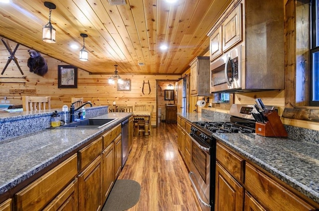 708 Split Creek Ln, Broken Bow, OK 74728 - kitchen with stainless steel appliances, wood finished floors, wood ceiling, wood walls, and pendant lighting