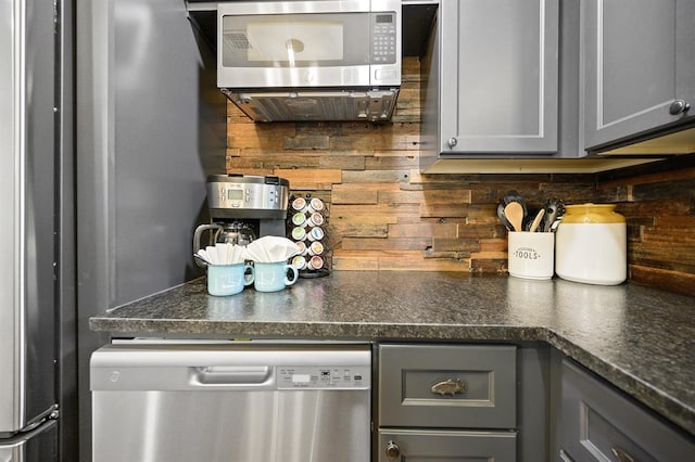 99 Sawtooth Pine Rd, Broken Bow, OK 74728 - kitchen with stainless steel appliances, gray cabinetry, and decorative backsplash